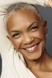 Portrait of a smiling Black woman looking at the camera.
